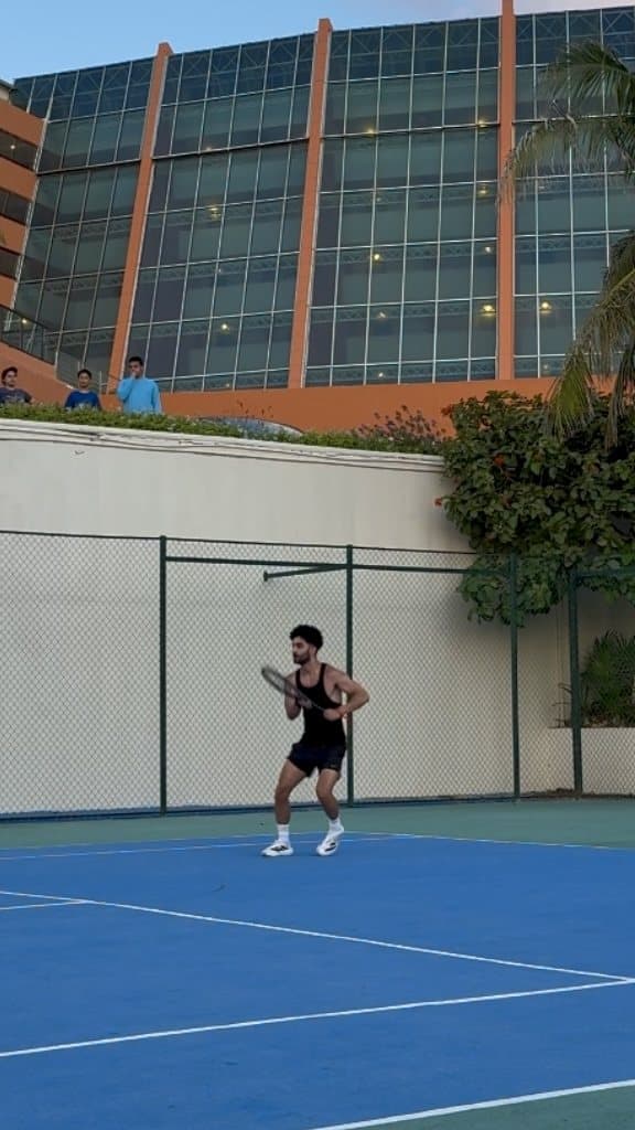 Mahyar playing tennis on an outdoor court